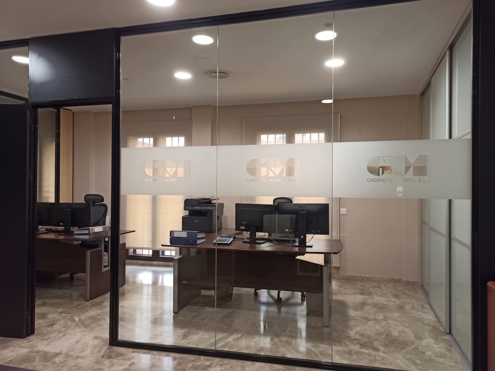 Despacho de Gabinete Mompó S.L. tras la mampara de cristal grabada con el logotipo de la empresa